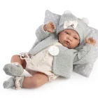 Muñeca Recién Nacida Lúa recostada sobre un cojín gris de estrellas, con conjunto gris, gorro con lazo y chupete a un lado.