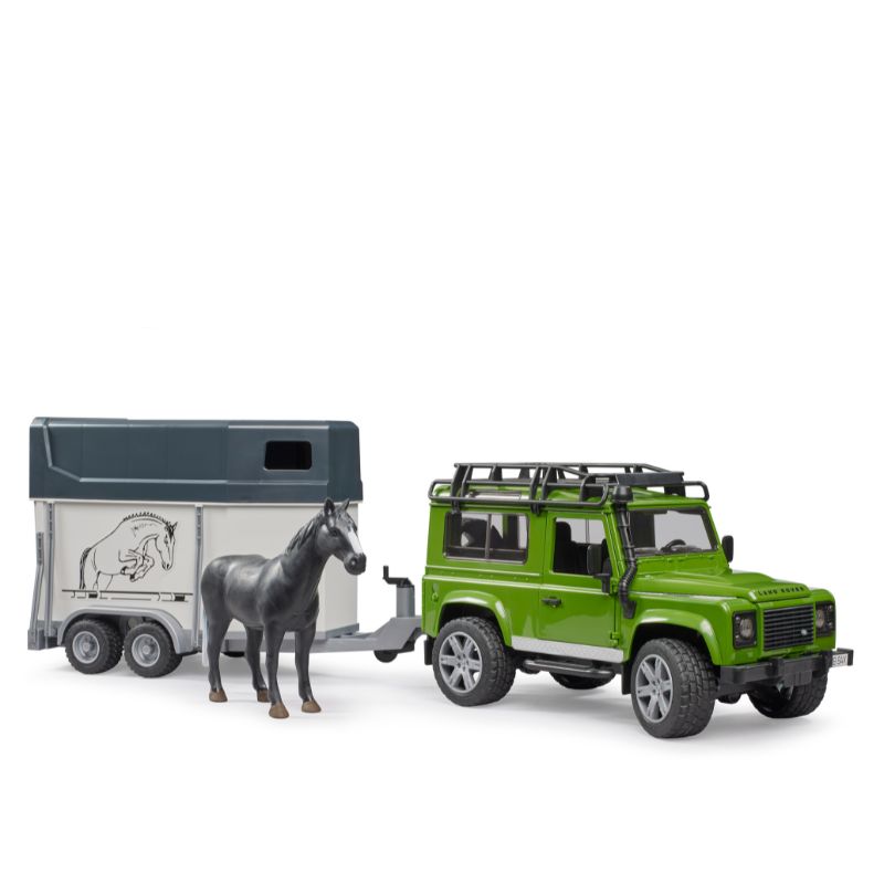 Land Rover Defender con Remolque de Caballos 02592 Bruder Land Rover Defender verde con remolque gris para caballos y un caballo gris entre ambos vehículos.