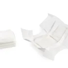 Varios pañales blancos para muñeca Antonio Juan apilados junto a un pañal abierto.