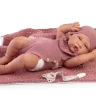 Muñeca Sweet Reborn Lúa de Antonio Juan recostada sobre una manta rosa con gorro y conjunto de punto malva.