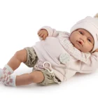 Muñeco Babydoo Posturitas Urban de Antonio Juan recostado de lado, con gorro de pompón, conjunto rosa y gris, calcetines de cuadros y chupete.