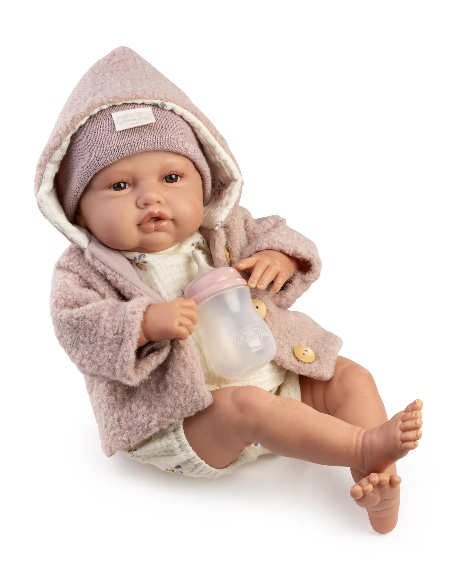 Muñeca Reborn Baby Love Invierno en primer plano, con capucha rosa y un biberón entre las manos.